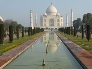 Beautiful shot of the iconic Taj Mahal reflecting in the water with a clear blue sky.