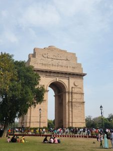 Crowd at the iconic India Gate under a clear sky in New Delhi, India.